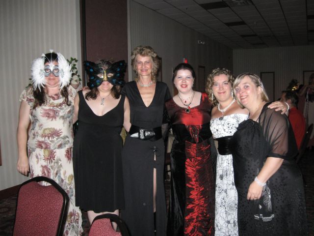 The Girls at RAW - five women in fancy dress, two wearing masks